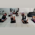 Alunas deitadas em colchonetes durante a aula de ABS